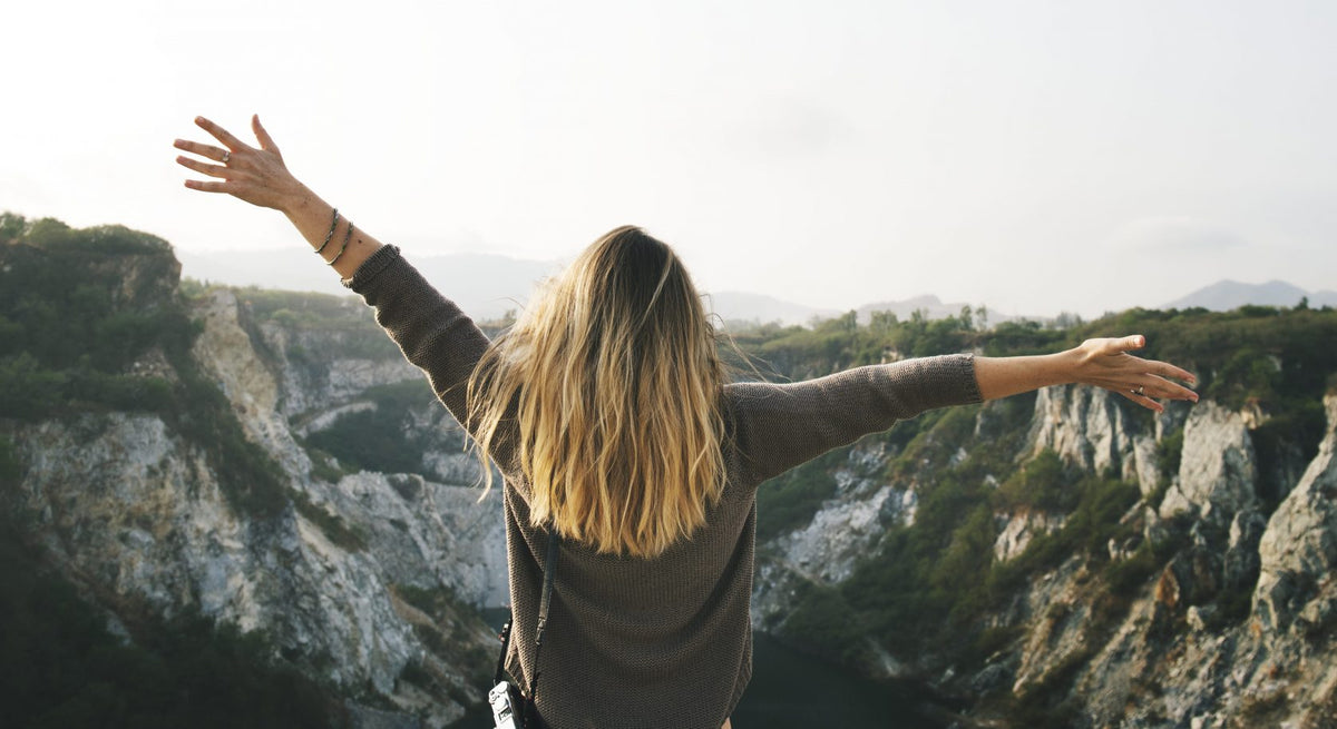 Carefree woman arms outstretched on the mountain