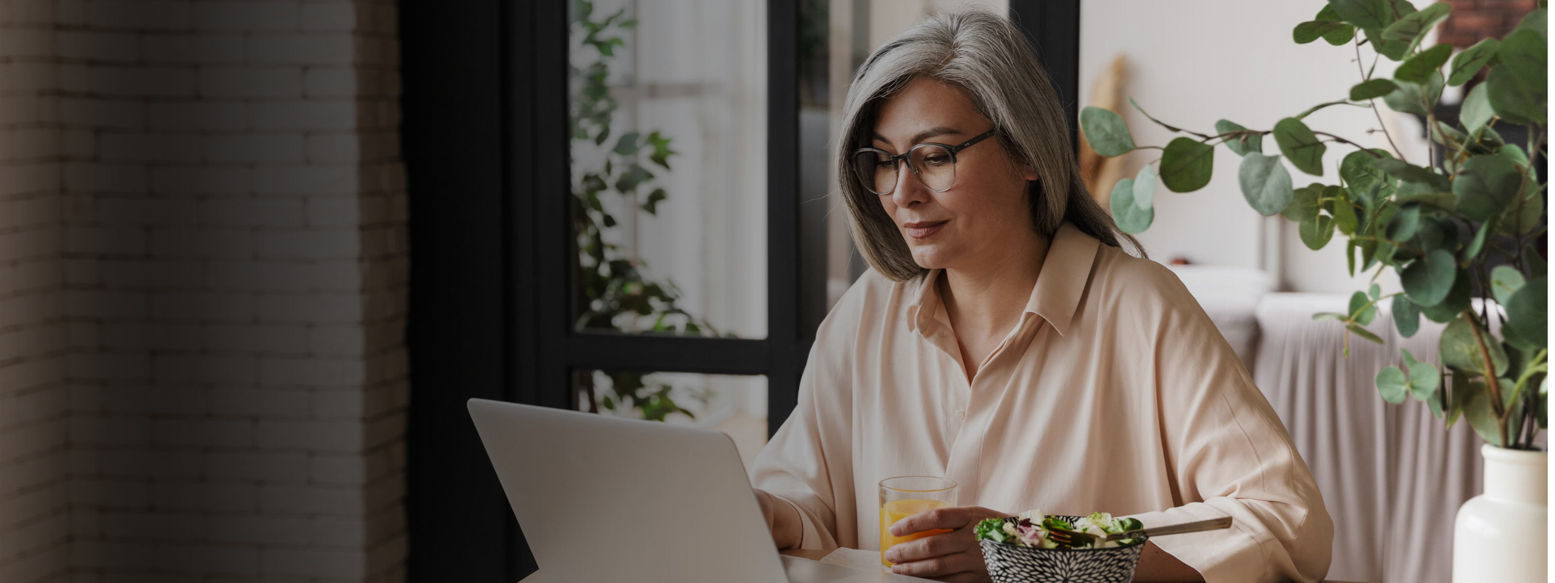 Mid-age woman using laptop to access Midlife Solutions' Hormone Hub Learning Center