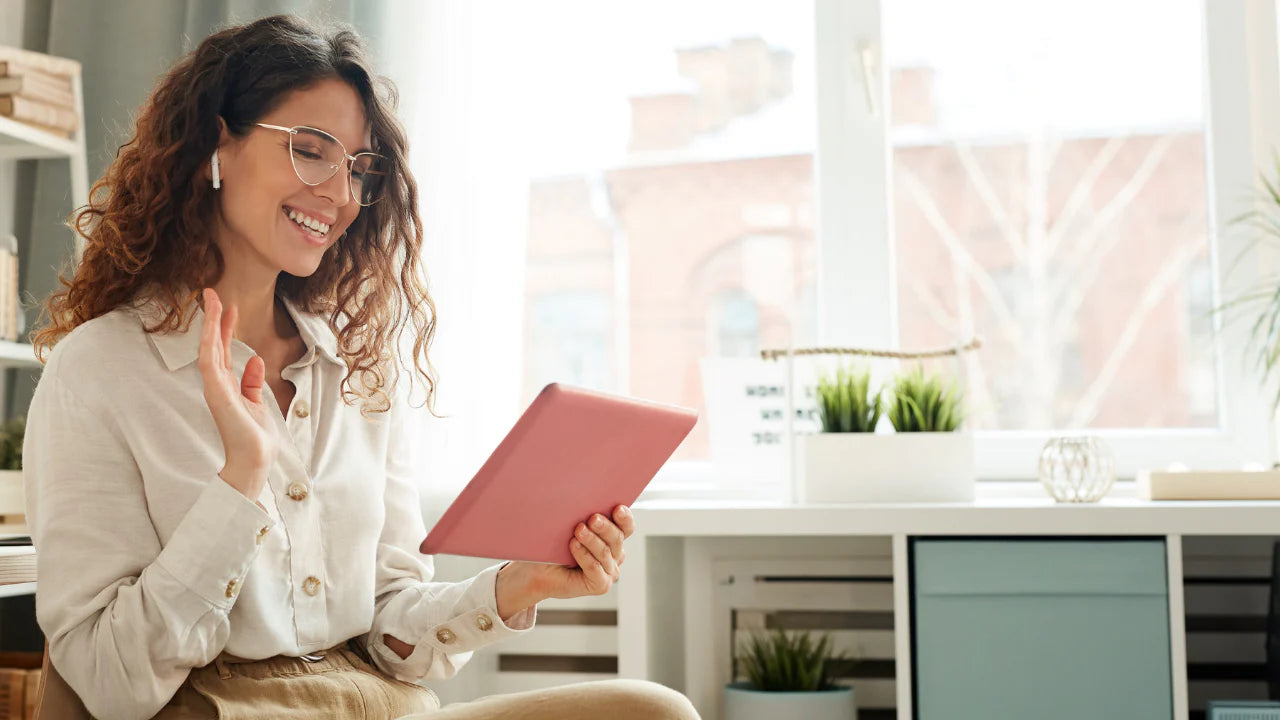 Smiling woman using her iPad to participate in private hormone coaching with Midlife Solutions and Karen Martel